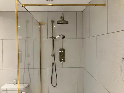 a bathroom with a shower with a shower head at Cherry Tree Cottage in Stranraer