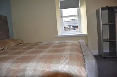 a bedroom with a bed and a window at The Blue House holiday home in Egremont