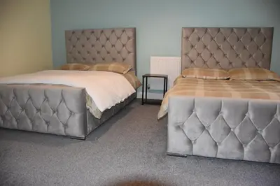 two beds sitting next to each other in a bedroom at The Blue House holiday home in Egremont