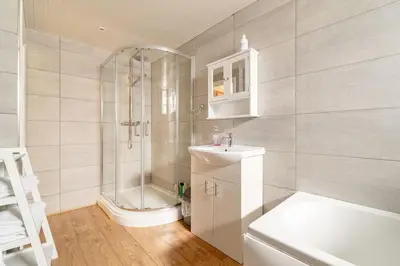 a bathroom with a shower and a sink and a toilet at The Blue House holiday home in Egremont