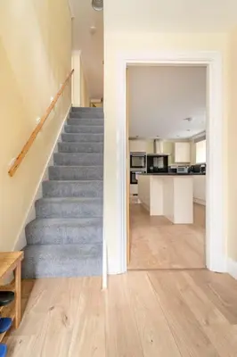 a staircase leading to a kitchen and a living room at The Blue House holiday home in Egremont