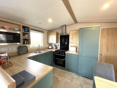 a kitchen with blue cabinets and a stove top oven at Beautiful 2BR In Kippford With Incredible Views - Pass the Keys in Palnackie