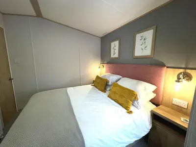 a bedroom with a large white bed with two pillows at Beautiful 2BR In Kippford With Incredible Views - Pass the Keys in Palnackie