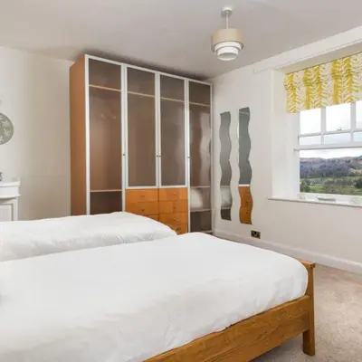a bedroom with two beds and a window at Bramrigg House in Grasmere