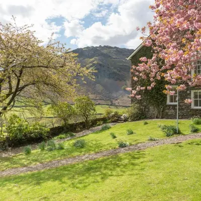 a house with a tree with pink flowers on it at Bramrigg House in Grasmere