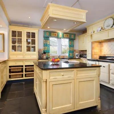 a large kitchen with white cabinets and a black counter top at Bramrigg House in Grasmere