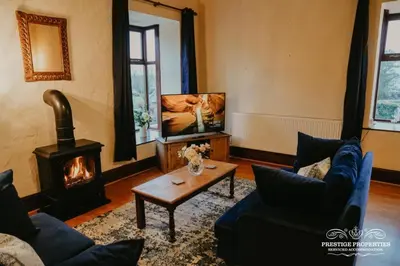 a living room with a fireplace and a tv at Pine lodge by Prestige Properties SA in Seascale