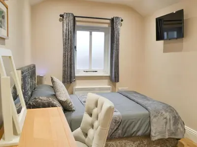 a bedroom with a bed and a window at Bumble Cottage in Cockermouth