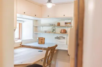 a room with a table with a chair and shelves at Slater Bob's Coppermines Valley in Coniston