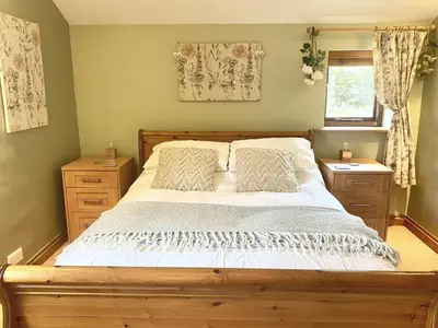 a bedroom with a large bed and two night stands at Slater Bob's Coppermines Valley in Coniston