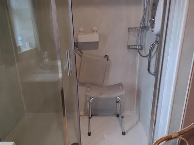 a shower with a chair in a small bathroom at lake District cottage in Bootle
