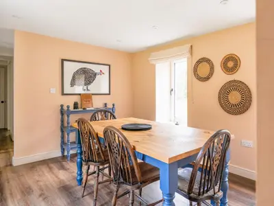 a dining room with a blue table and chairs at Cleugh Foot in Longtown