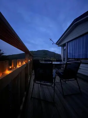 two chairs sitting on the deck of a house at JS Holidays The Westmorland Lagganhouse in Ballantrae