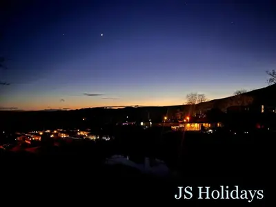a view of a city at night with the moon at JS Holidays The Westmorland Lagganhouse in Ballantrae