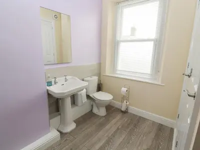 a bathroom with a sink and a toilet and a window at Cobbleken in Cockermouth