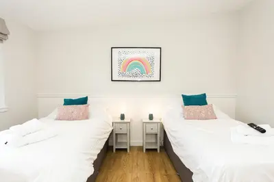 two beds in a room with a rainbow on the wall at Ocean Drive in Gatehouse of Fleet