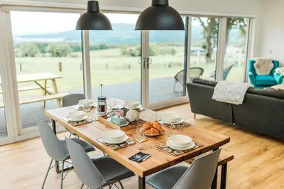 a dining room with a wooden table and chairs at Ocean Drive in Gatehouse of Fleet