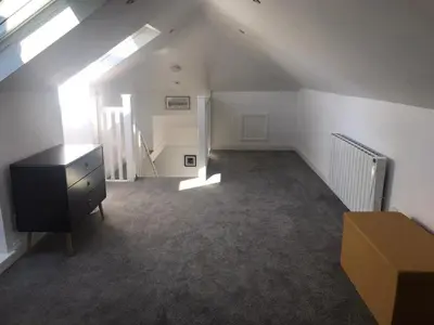an attic room with a dresser and a staircase at Mallaig in Rockcliffe