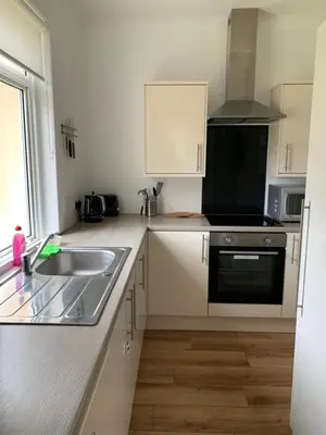 a kitchen with a sink and a stove at 10 Burns Street, Tarbolton KA5 5RA in Tarbolton