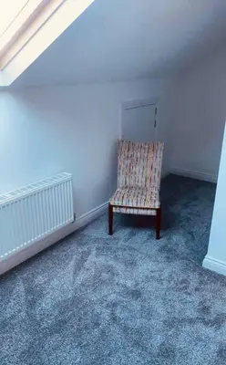 a chair sitting in a corner of a room at Luxury 2 bed apt 4 mins from M6 J44 pet friendly, in Carlisle