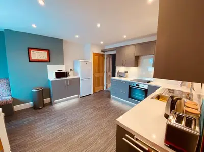 a large kitchen with blue and white appliances at Luxury 2 bed apt 4 mins from M6 J44 pet friendly, in Carlisle
