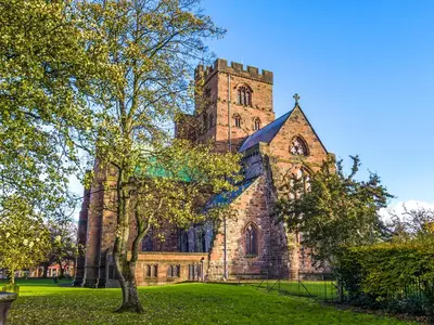 an old church with a tower on a green field at Sycamore Cottage in Ellonby