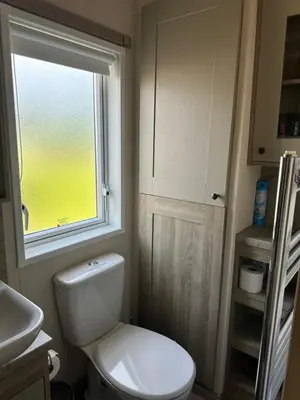 a small bathroom with a toilet and a window at Luxury Lake District Holiday Lodge-Sleeps 4 in Cockermouth