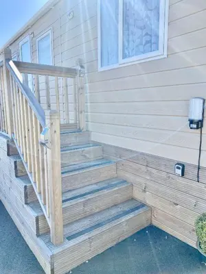 a wooden staircase leading up to a house at Luxury Lake District Holiday Lodge-Sleeps 4 in Cockermouth