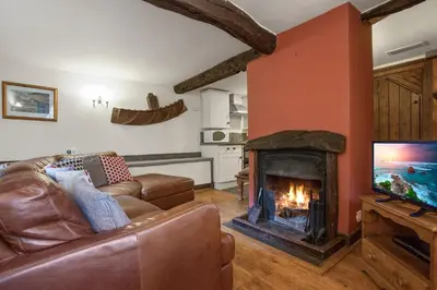 a living room with a couch and a fireplace at The Coppermines Mountain Cottages Sawyers, Carpenters, Millrace, Pelton Wheel, Sleeps 22 in Coniston