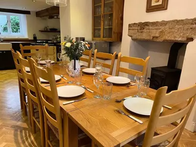 a wooden table with chairs and a dining room at House - Sleeps 10 Pet friendly & Parking in Wigton