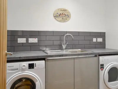 a kitchen with a sink and a washing machine at Old Byre Cottage - Uk43377 in Kirklinton