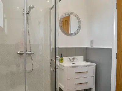 a bathroom with a shower with a sink and a mirror at Fell View Cottage - Uk43378 in Kirklinton