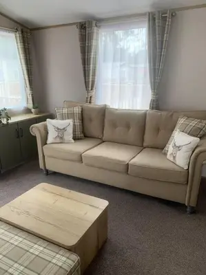 a living room with a couch and a table at Grasmere Lodge Unit 31 in Carlisle