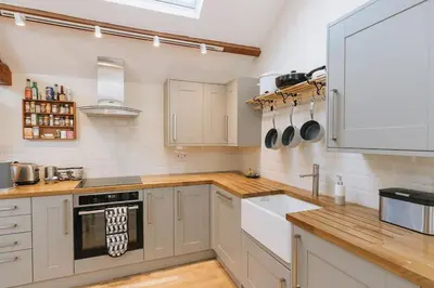 a kitchen with white cabinets and a sink at ELM HOUSE BARN - Converted One Bed Barn at the gateway to the Lake District National Park in High Hesket