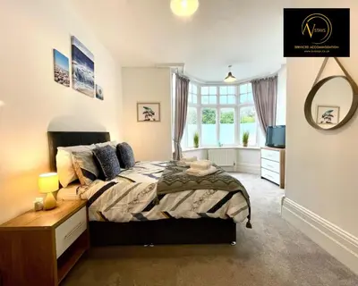 a bedroom with a bed and a large window at Three Bedroom in Seascale