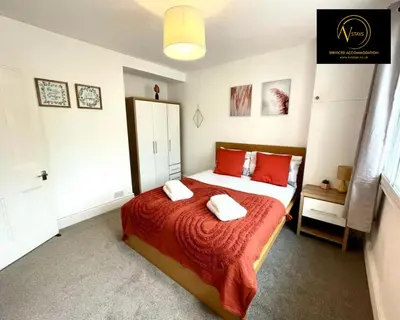 a bedroom with a bed with two towels on it at Three Bedroom in Seascale