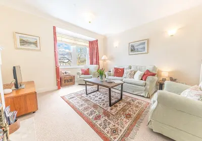 a living room with a couch and a table at 7 Greta Grove House in Keswick
