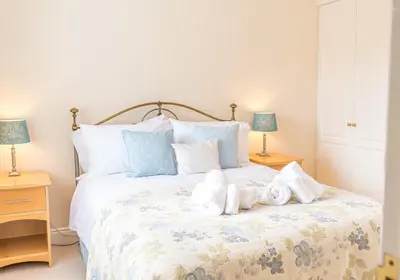 a bedroom with a bed with two stuffed animals on it at 7 Greta Grove House in Keswick