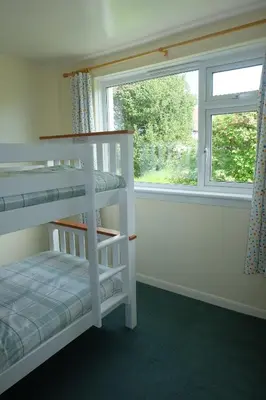 a bedroom with two bunk beds and a window at Tir Nan Og in Rockcliffe