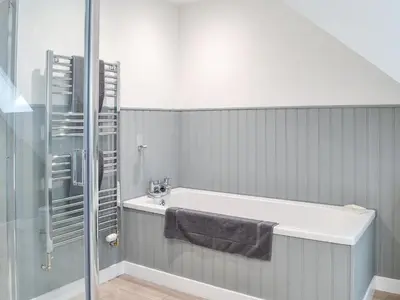 a bathroom with a bath tub and a shower at Crofthouse - Uk43405 in Wigtown