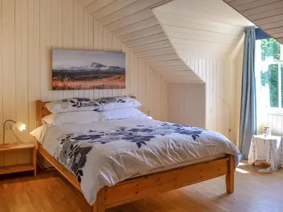 a bedroom with a large bed with white sheets and pillows at Mossdale in Rockcliffe