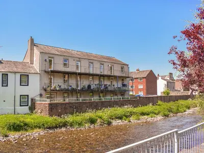 a building on the side of a river at Hatters Croft in Cockermouth