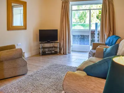 a living room with two couches and a flat screen tv at Hatters Croft in Cockermouth