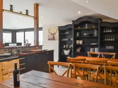 a kitchen and dining room with a table and chairs at The Coach House in Blencogo