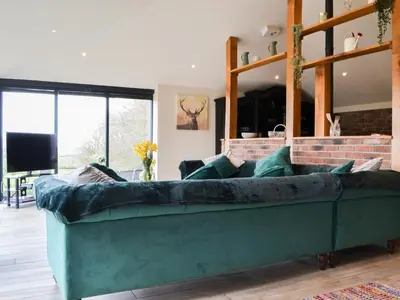 a green couch in a living room with a fireplace at The Coach House in Blencogo