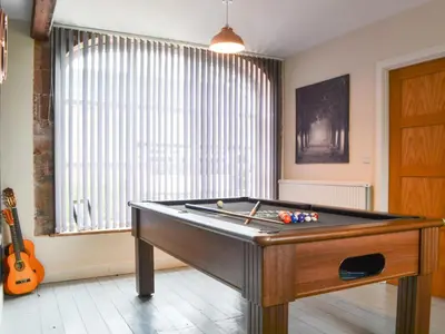a room with a pool table in front of a window at The Coach House in Blencogo