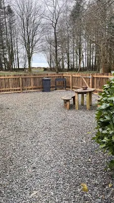 a park with two benches and a wooden fence at Wrens nest in Newton Stewart