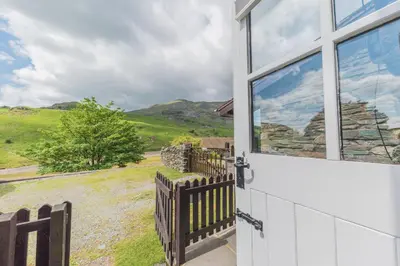 a window of a house with a view of the countryside at Fellside Cottage Coppermines Valley in Coniston