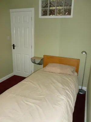 a bedroom with a bed with a white bedspread at The Coach House, Hesket Newmarket in Hesket Newmarket
