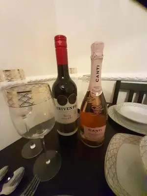 two bottles of wine and a glass on a table at Kirkcudbright Holiday Apartments - Apartment E in Kirkcudbright